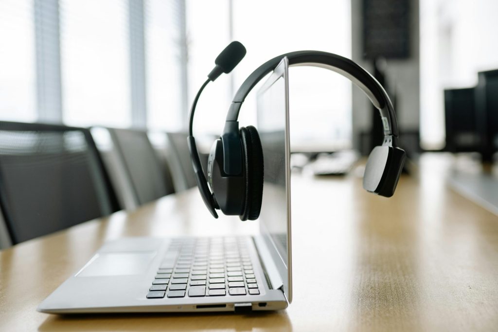 A Black Headset Microphone Hanging on the Laptop Screen